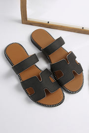 Black leather slides with H band design and cushioned footbed.