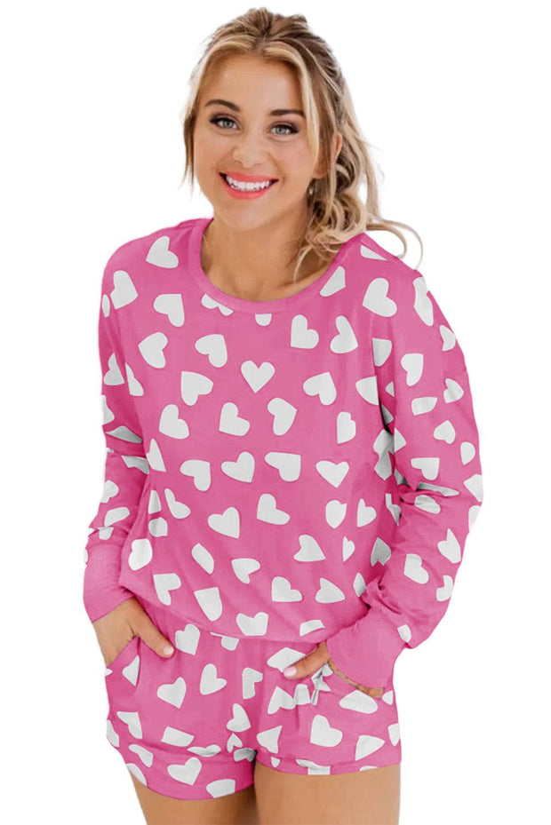 Pink loungewear set with white heart print, featuring a matching top and shorts.