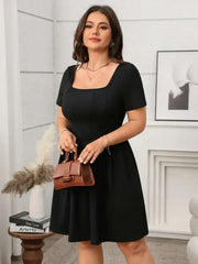 Plus size square-neck short-sleeve mini dress in black, styled with a brown handbag.
