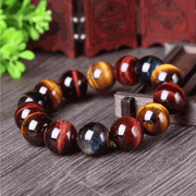 Tiger Eye Bracelet with natural crystal beads featuring golden and brown hues on a rustic wood surface.