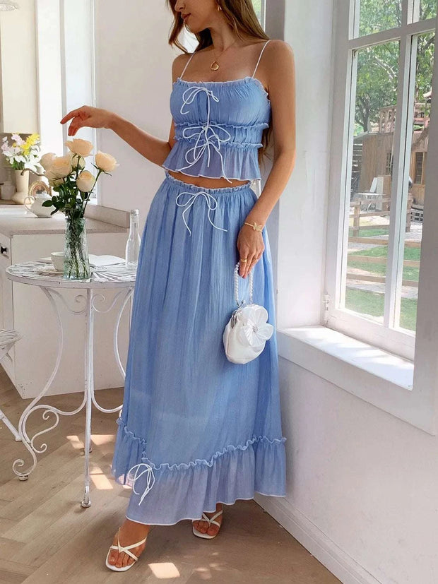 Frill Square Neck Cami and Skirt Set in blue with delicate frills and A-line silhouette, styled with white sandals and purse in a bright room.