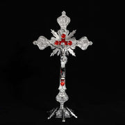 Vibrant religious cross ornament with intricate designs and red accents.