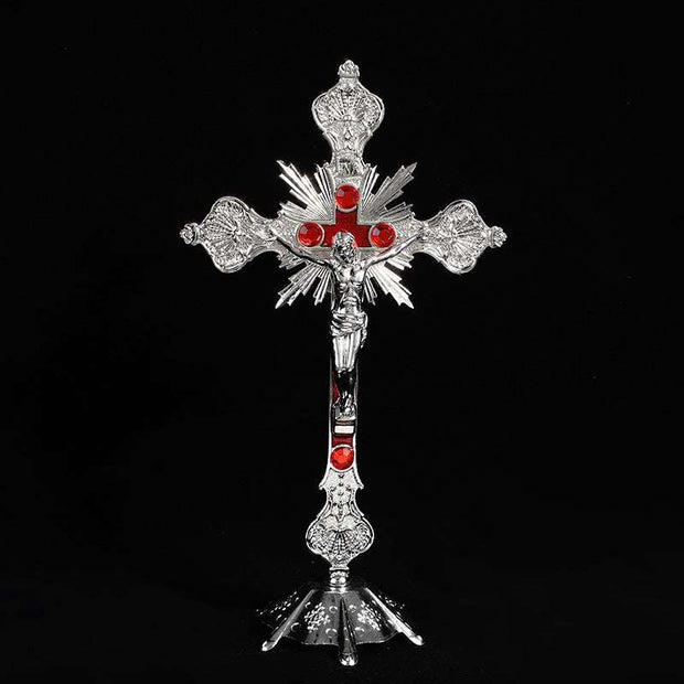 Vibrant religious cross ornament with intricate designs and red accents.