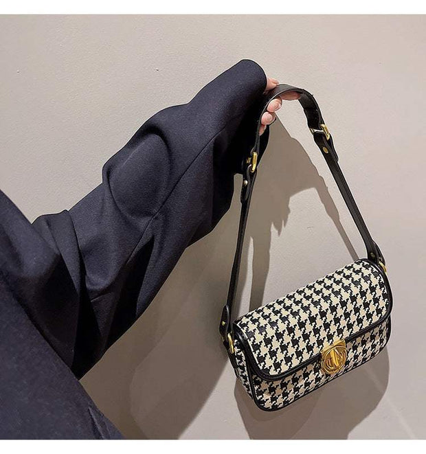 Houndstooth Baguette Bag with gold clasp and black shoulder strap.