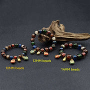 Gray colored glaze bracelet with geometric beads in three sizes: 10mm, 12mm, 14mm, displayed against a dark background with decorative wood.