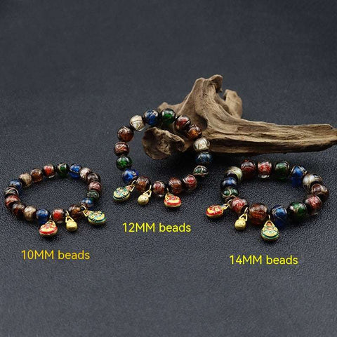 Gray colored glaze bracelet with geometric beads in three sizes: 10mm, 12mm, 14mm, displayed against a dark background with decorative wood.