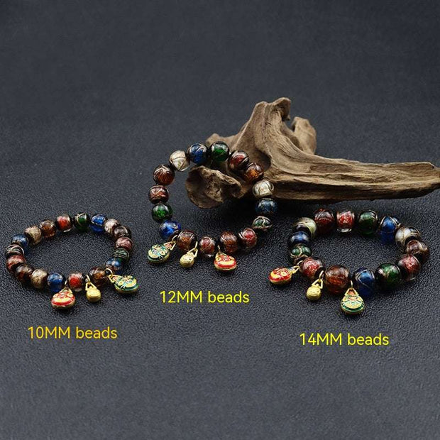 Gray colored glaze bracelet with geometric beads in three sizes: 10mm, 12mm, 14mm, displayed against a dark background with decorative wood.