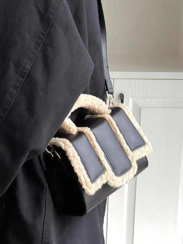 Black lambs wool crossbody bag with soft texture and PU detailing.