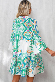 White Boho Print Mini Dress with vibrant ethnic design and ruffled hems, perfect for summer vibes.