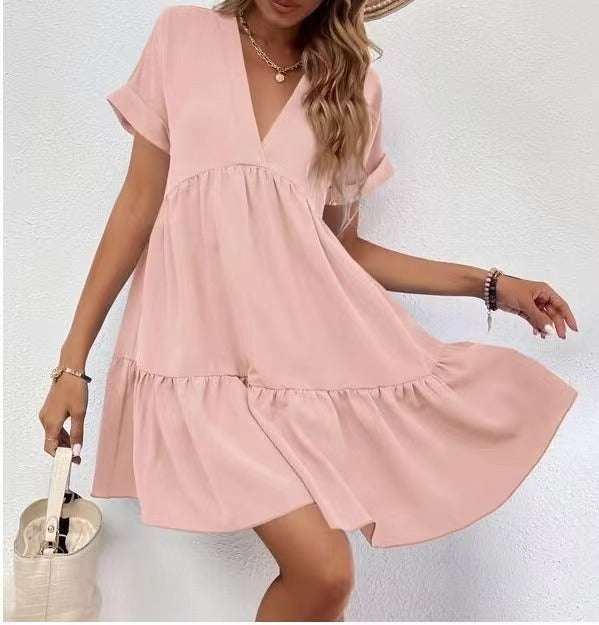 Short-sleeved V-neck dress in pink with flowy skirt, perfect for versatile styling and comfort.