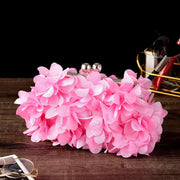 Pink bridal clutch with floral detailing, perfect wedding accessory for brides.