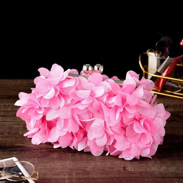 Pink bridal clutch with floral detailing, perfect wedding accessory for brides.