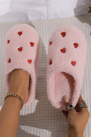Pink heart embroidered plush slippers with cozy, soft material.