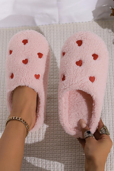 Pink heart embroidered plush slippers with cozy, soft material.