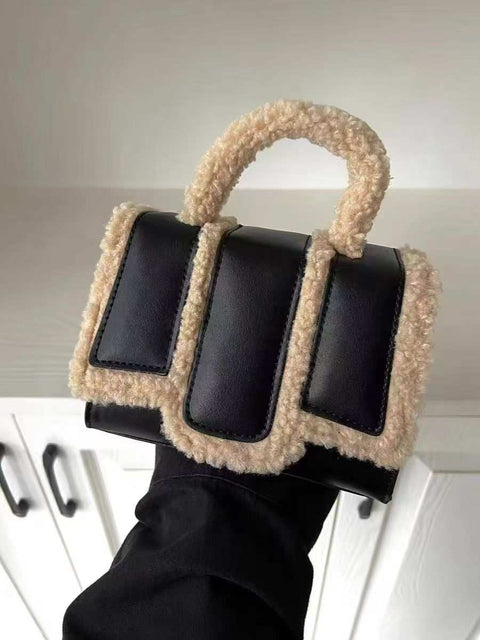 Black lambs wool crossbody bag with PU trim and handle.