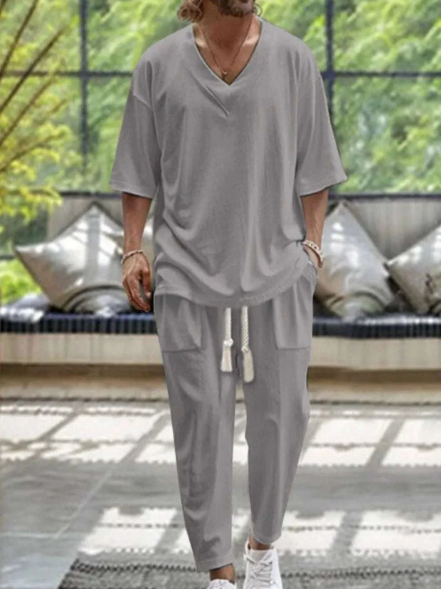 Men's gray V-neck half sleeve top and pants set, casual stylish outfit.