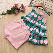 Cake Skirt Camisole Set with pink shorts and playful design on wooden background.