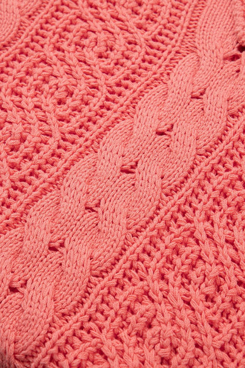 Close-up of coral cable-knit pattern on hooded sweater fabric.