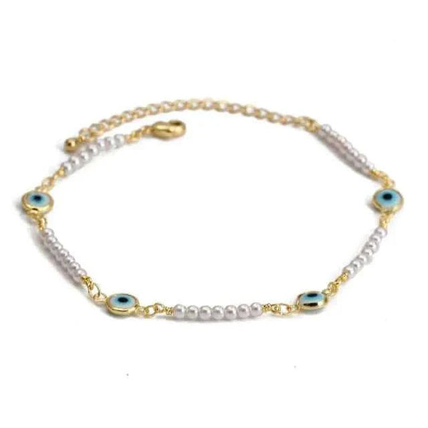 Delicate charm bracelet with blue eye motifs and pearl beads, featuring a secure clasp, ideal for self-expression and personal storytelling.