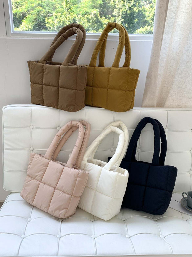 Large Capacity Hand Bag in assorted colors displayed on a white couch.