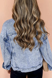 Woman wearing a light blue, dropped shoulder denim jacket with long wavy hair.