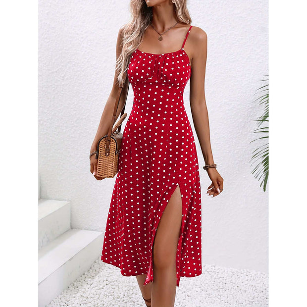 Red polka dot suspender dress with front slit, adjustable straps, and fitted bodice for a vintage-inspired look.