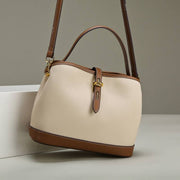 Milky white ladies messenger bag with adjustable strap and brown accents, designed for modern women.