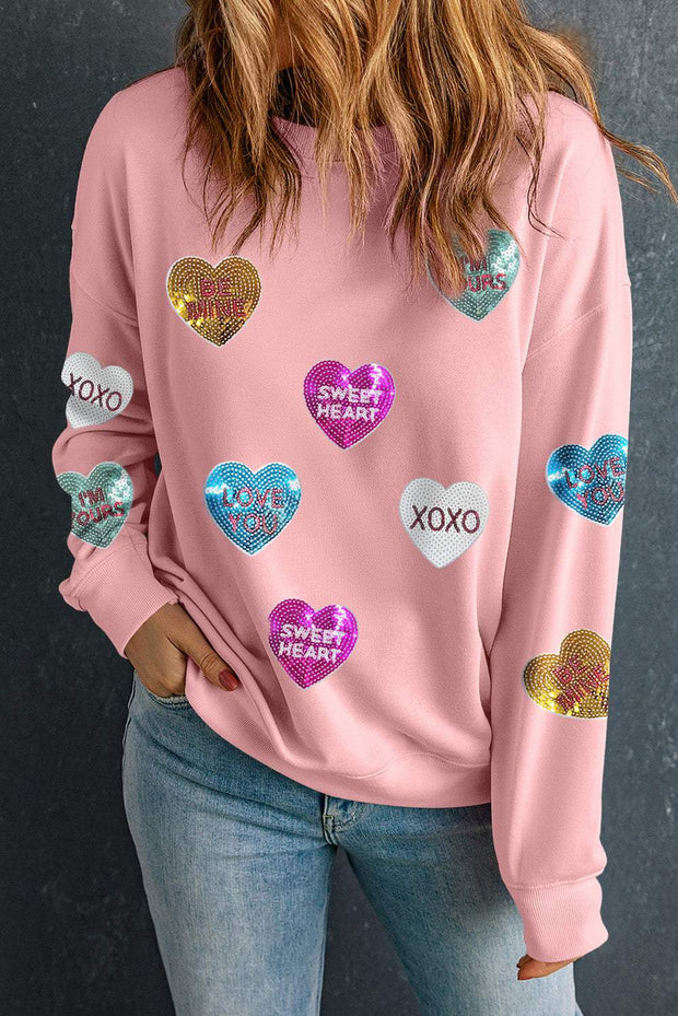 Pink graphic Valentines sweatshirt with sequin heart designs and romantic text.