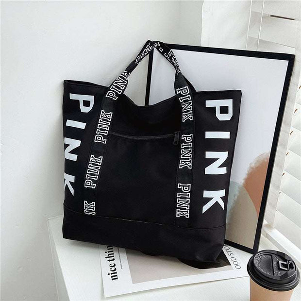 Large capacity black handbag with "PINK" lettering and dual handles.