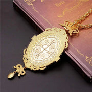 Orthodox Jesus Cross Pendant with intricate design and high-quality craftsmanship on religious book.