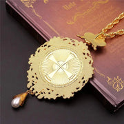Orthodox Jesus Cross Pendant with intricate design on a book background.