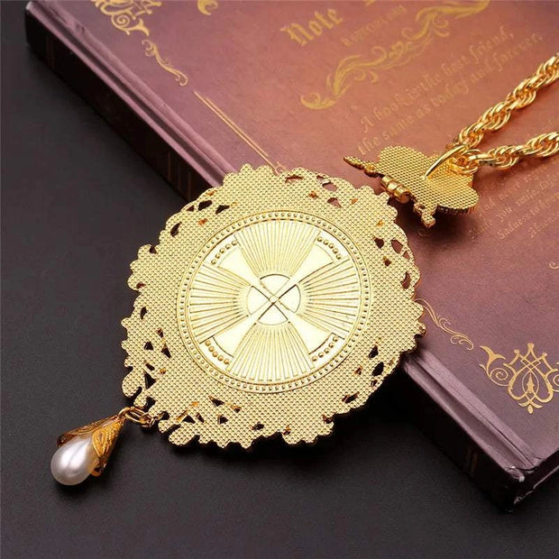 Orthodox Jesus Cross Pendant with intricate design on a book background.