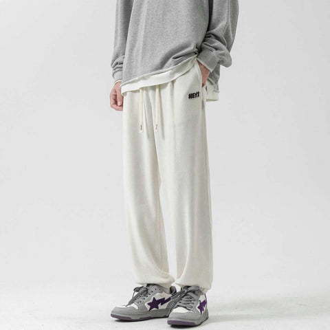 Straight-leg Sweatpants in milky white, featuring an elastic waistband with drawstring, worn with a casual gray top.