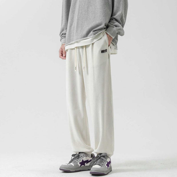 Straight-leg Sweatpants in milky white, featuring an elastic waistband with drawstring, worn with a casual gray top.