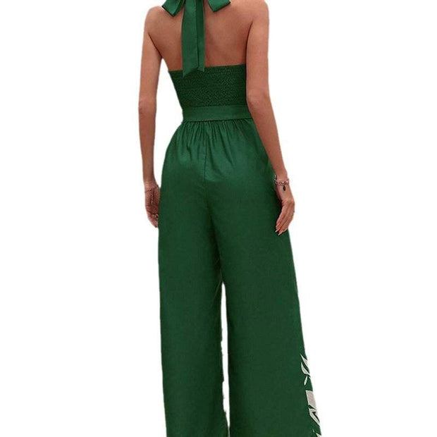 Backless halter jumpsuit in green, featuring a high waist and flowing trousers.