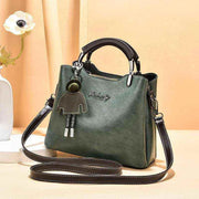 Elegant green small retro handbag with shoulder strap and charm accessory.