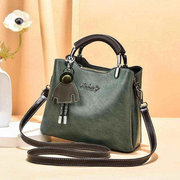 Elegant green small retro handbag with shoulder strap and charm accessory.