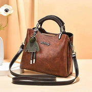 Small Retro Handbag in brown PU leather with black straps, featuring vintage design and charm.