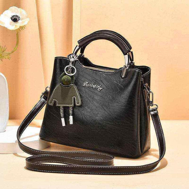 Small Retro Handbag with shoulder strap and top handle in black PU material.