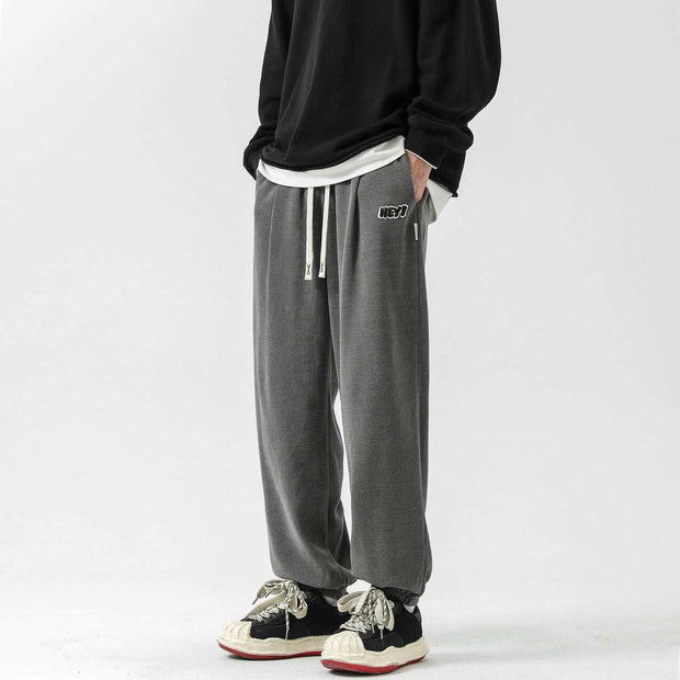 Straight-leg sweatpants in gray with an elastic waistband and drawstring, styled for casual comfort.