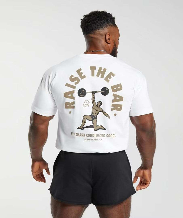 Mens short sleeve shirt with weightlifting design, featuring "Raise the Bar" text on the back.