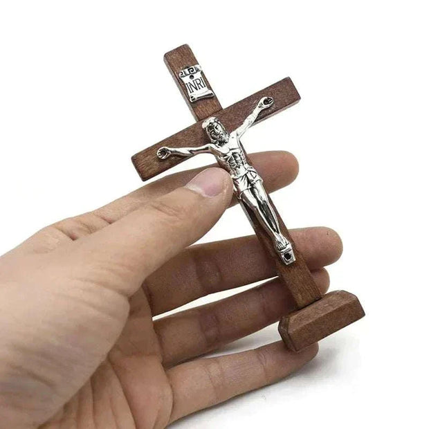Wooden Jesus cross with stand, intricately detailed religious decor, warm wooden finish, fits shelves and mantels.