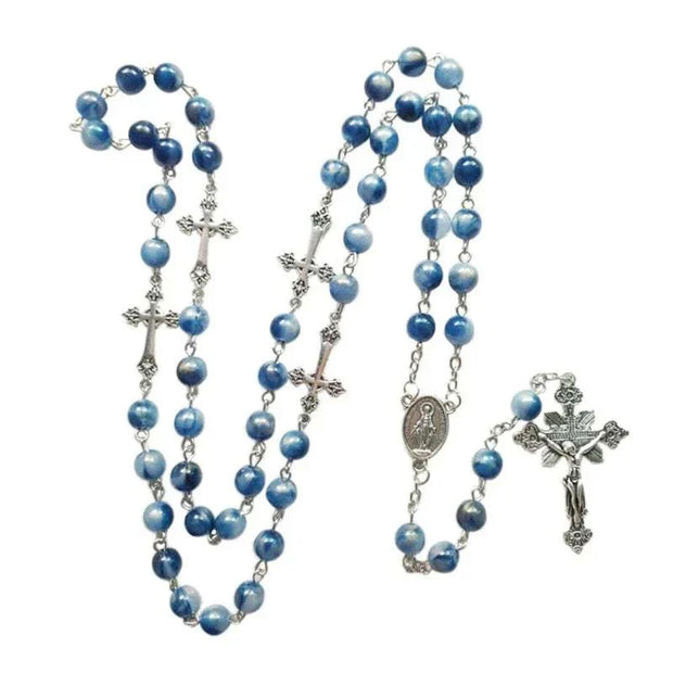 Rosary necklace with blue beads and silver cross pendant, showcasing elegance and spirituality.