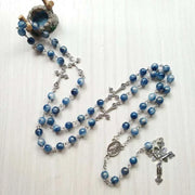 Rosary necklace with cross pendant featuring blue beads, symbolizing spirituality and faith.
