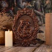 Religious Holy Family Wooden Icon with intricate carvings of Jesus, Mary, and Joseph, displayed alongside a lit candle for a spiritual ambiance.