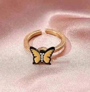 Fidget Spinner Ring with butterfly design on pink fabric background.