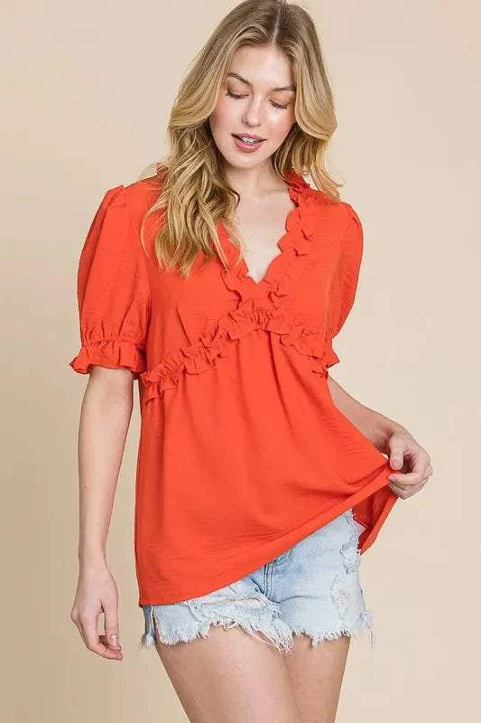 Vibrant orange ruffled puff sleeve babydoll top with a deep V-neckline and frill details.