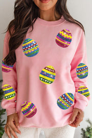 Pink crew neck sweatshirt with colorful sequined egg design, perfect for casual wear and versatile style.