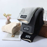 Cashmere leggings in grey, black, and beige displayed on a table, showcasing their thick, warm material.