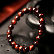 Red Tiger Eye Bracelet with polished beads, promoting strength and courage in a vintage style.